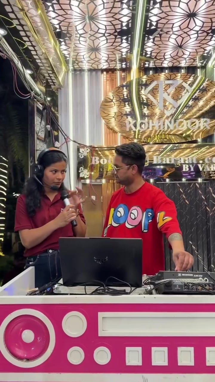 Book My Baraat team member speaking with the DJ beside a laptop and mixing console
