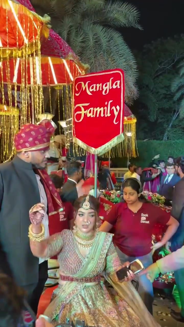 Wedding guests and our team accompanying the entry beneath illuminated baraat umbrellas